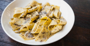 Truffle Pasta in a white dish on a black wooden table