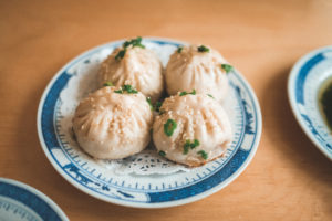Plate of soup dumplings on a blue and white china plate