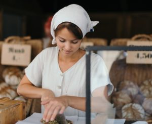 Woman cutting bread at a bakery